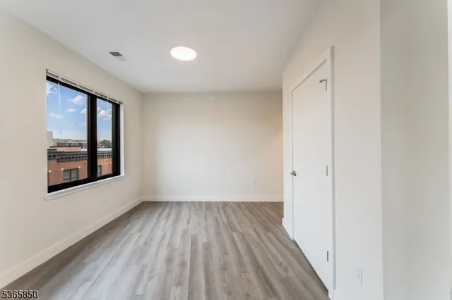 a view of a room with wooden floor and window