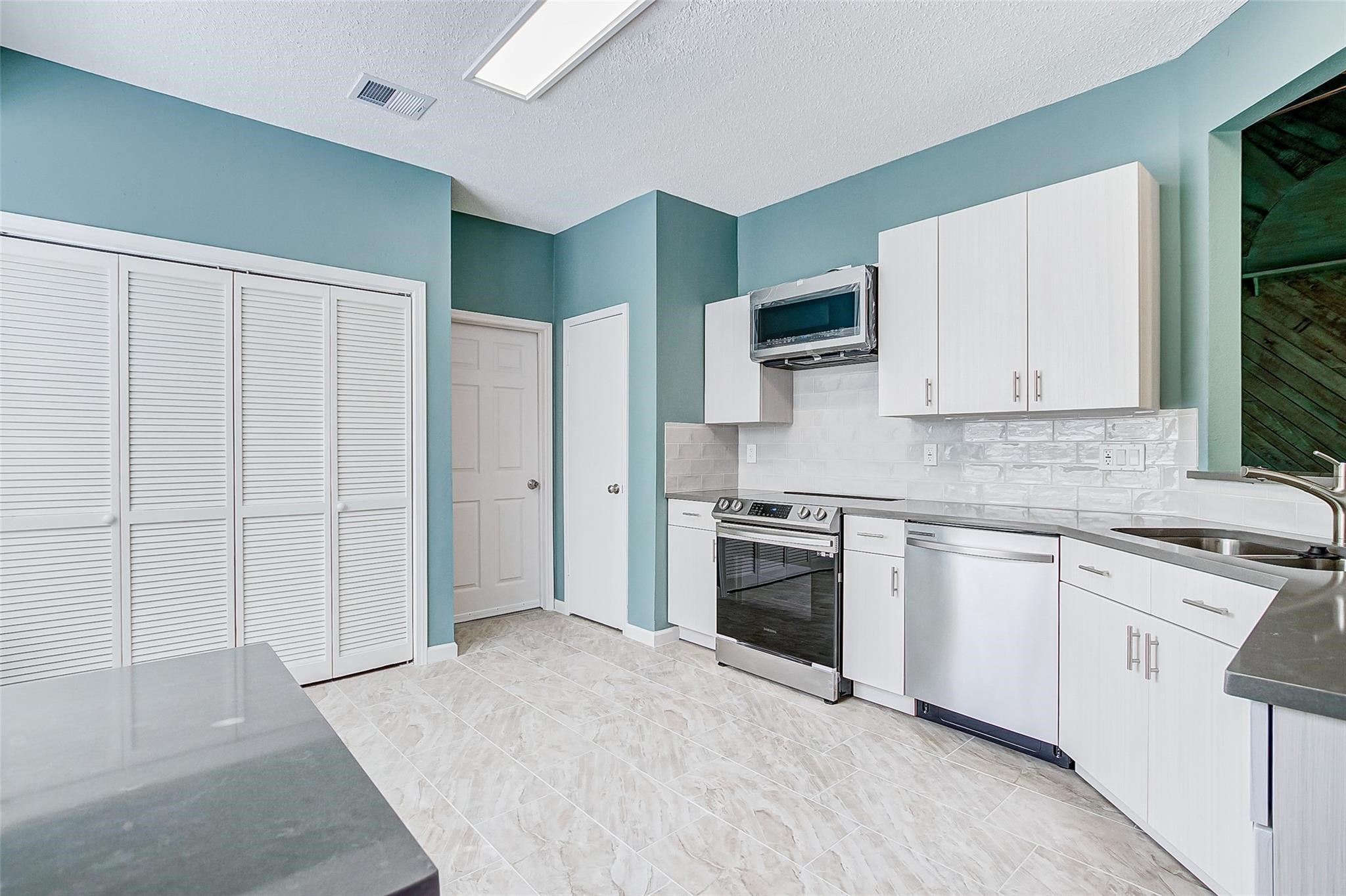 3207 Georgia Pine Drive Spring, TX 77373 - Photo 8 of 29 a kitchen with stainless steel appliances granite countertop a stove a sink and a refrigerator