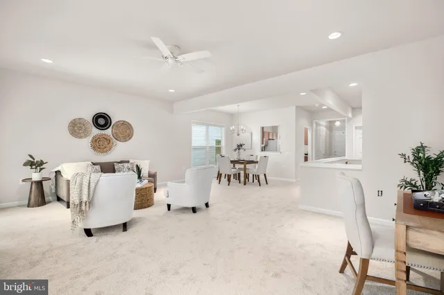 a living room with furniture and a view of kitchen