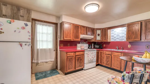 a kitchen with stainless steel appliances a stove a sink and a refrigerator