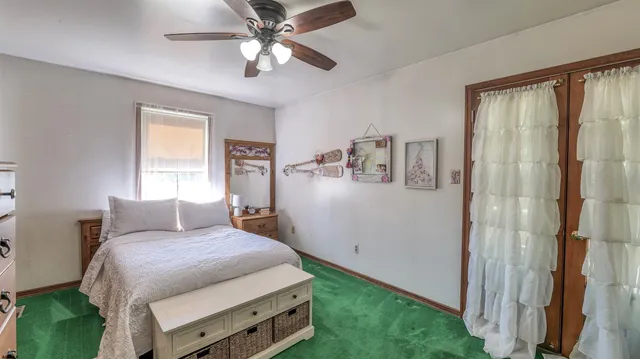 a bedroom with a bed chandelier and a window