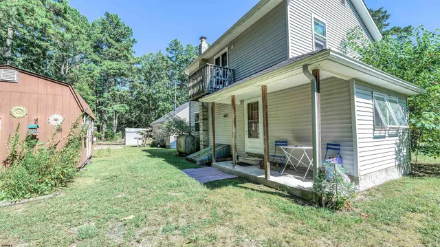a view of a chair and table in backyard of the house