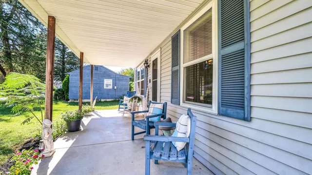 a view of house with backyard and sitting area