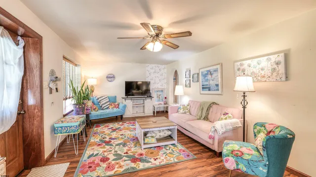 a living room with furniture a flat screen tv and a window