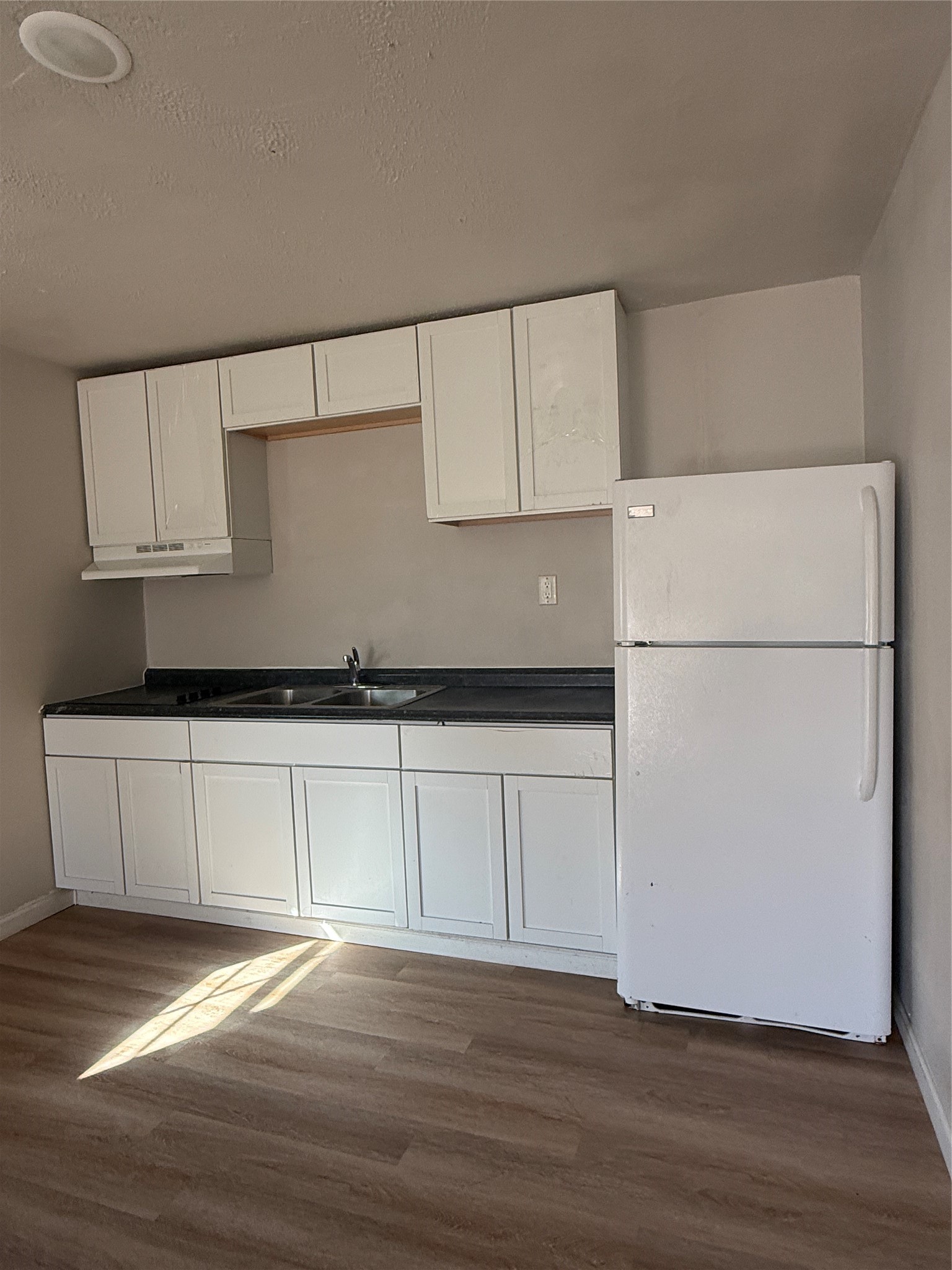 8510 Safeguard Street, Unit 3 Houston, TX 77051 - Photo 11 of 13 a kitchen with granite countertop white cabinets and a refrigerator