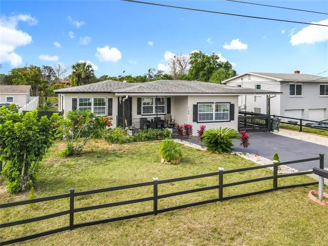 a view of a house with backyard and sitting area