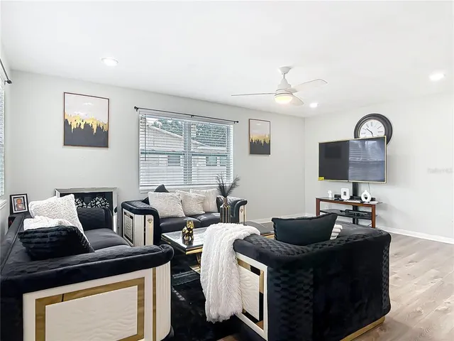 a living room with furniture a large window and a flat screen tv