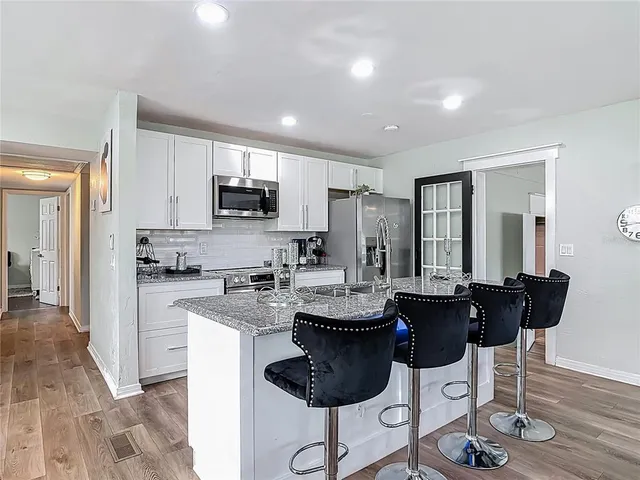 a kitchen with granite countertop a sink stove and refrigerator