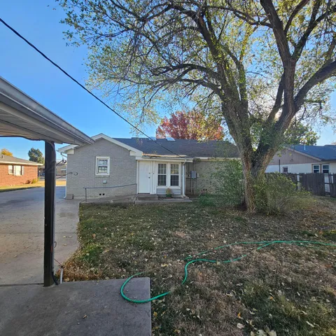 a view of a house with yard and a tree
