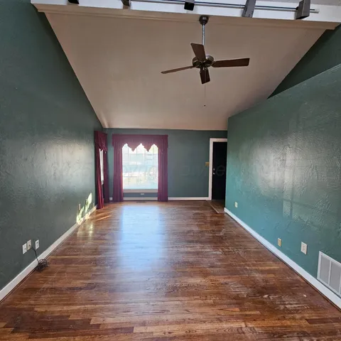 a view of empty room with wooden floor
