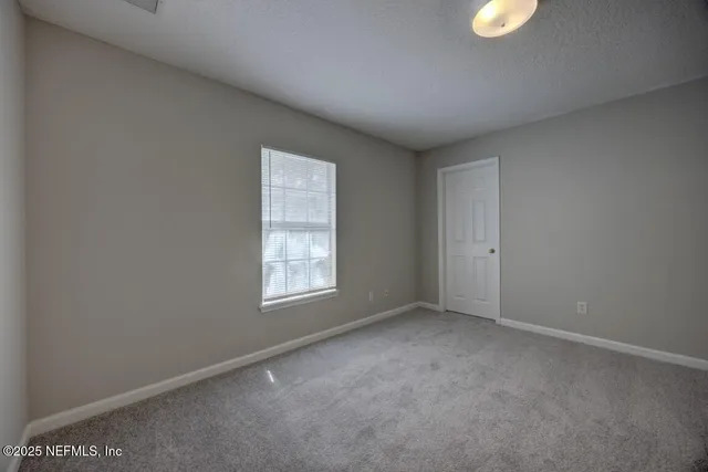 an empty room with windows and closet