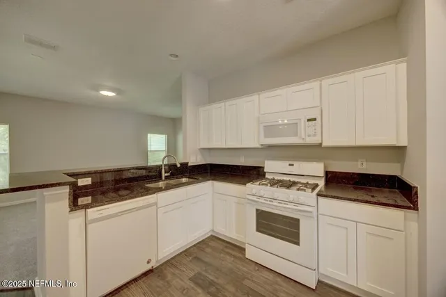 a kitchen with sink a stove and cabinets