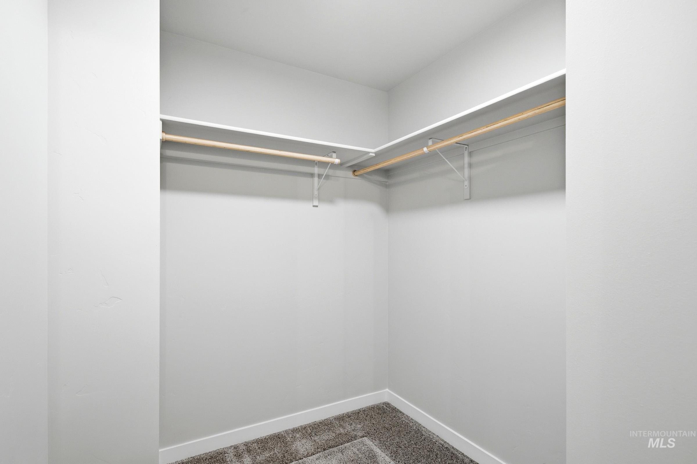 16632 North Shorthorn Loop Nampa, ID 83651 - Photo 17 of 17 Corner closet with white shelving, wood-finish hanging rods, and gray textured carpeting