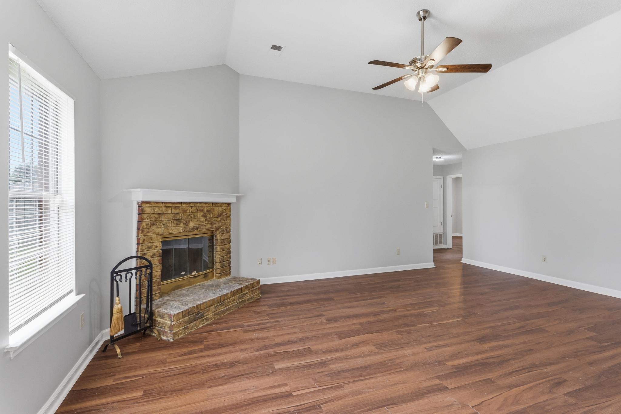 4101 Long Creek Road Memphis, TN 38125 - Photo 10 of 36 Living area featuring a brick-surround fireplace with a white mantel, high vaulted ceilings, wood-finish flooring, and a ceiling fan with light fixture