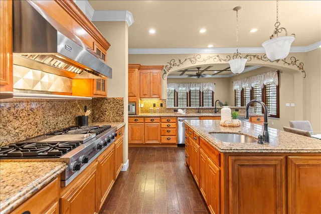 a kitchen with stainless steel appliances granite countertop a stove and a sink