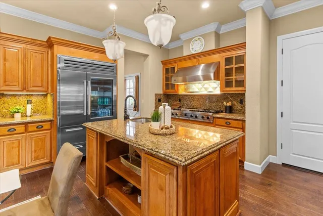 a kitchen with stainless steel appliances granite countertop a table and chairs in it