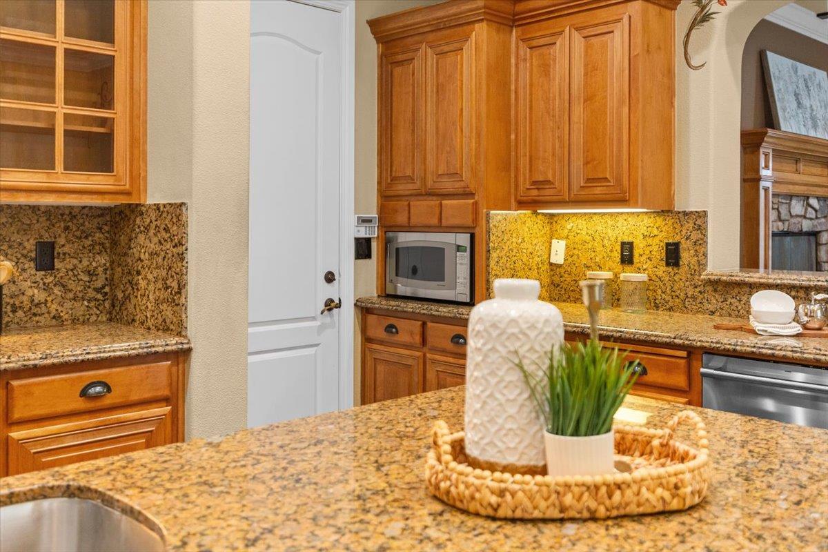 3168 Hutton Place Tracy, CA 95377 - Photo 18 of 94 a kitchen with a refrigerator a stove and a sink with wooden cabinets