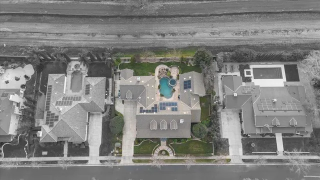 a view of a white house with many windows next to a yard