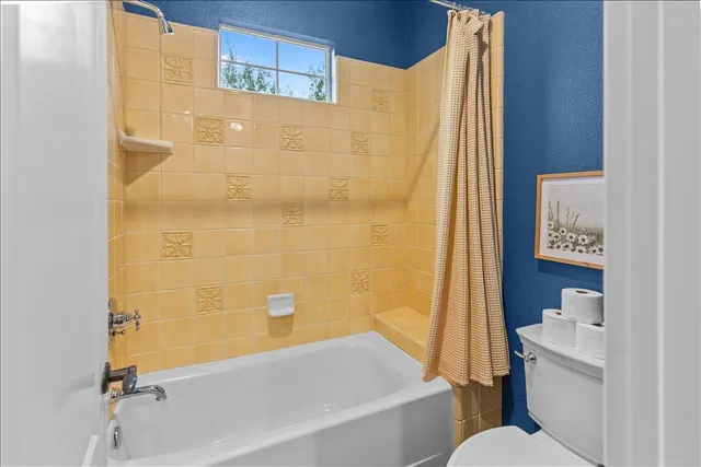 a spacious bathroom with a granite countertop sink a mirror and a bathtub