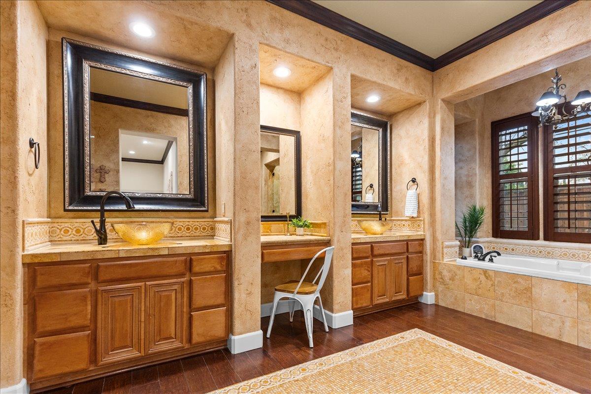 3168 Hutton Place Tracy, CA 95377 - Photo 44 of 94 a en suite bathroom with a double vanity sink a mirror a bathtub and a window