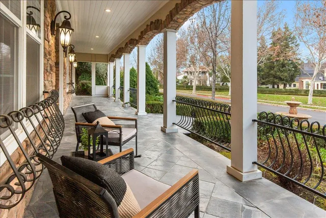 a kitchen with stainless steel appliances granite countertop a refrigerator a sink dishwasher a stove and a dining table with wooden floor