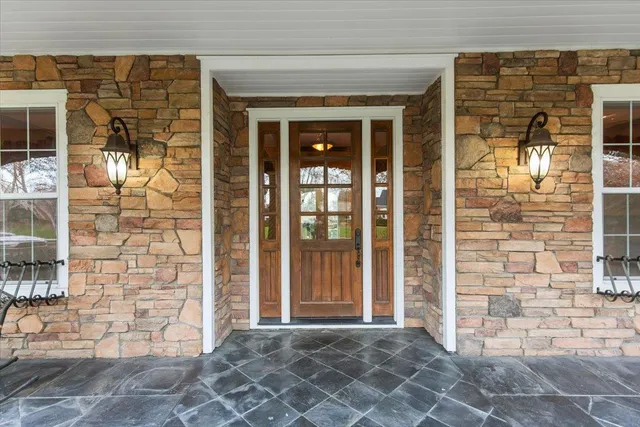 a kitchen with stainless steel appliances granite countertop a sink a stove and a dining table with wooden floor