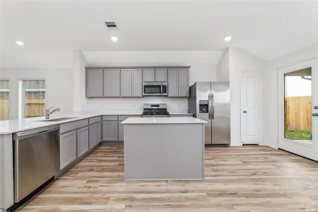 a kitchen with stainless steel appliances a refrigerator and a microwave