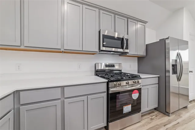 a kitchen with a refrigerator and a stove top oven