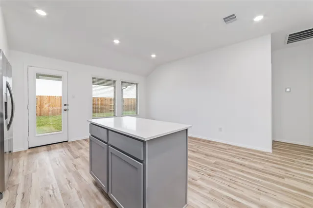 a kitchen with stainless steel appliances white cabinets and a stove top oven