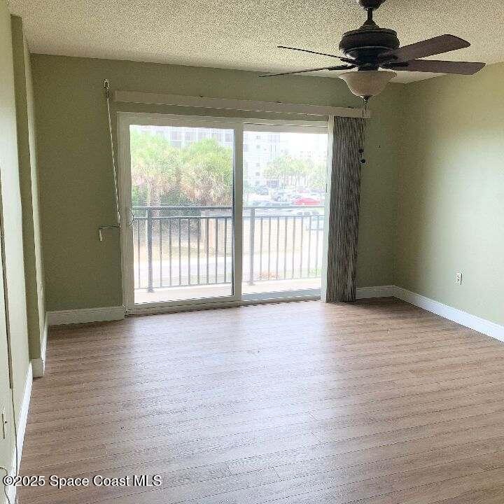 3060 North Atlantic Avenue, Unit 308 Cocoa Beach, FL 32931 - Photo 12 of 20 a view of an empty room with a window and wooden floor