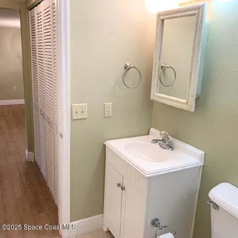 a bathroom with a sink mirror vanity and toilet