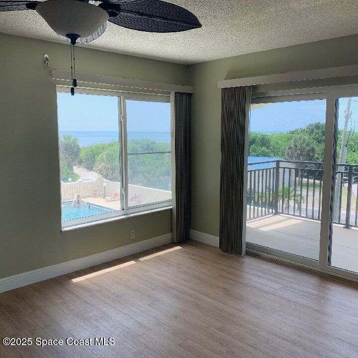 3060 North Atlantic Avenue, Unit 308 Cocoa Beach, FL 32931 - Photo 6 of 20 a view of an empty room with wooden floor and a window