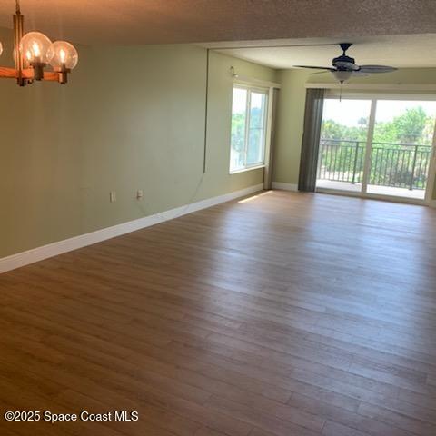 3060 North Atlantic Avenue, Unit 308 Cocoa Beach, FL 32931 - Photo 7 of 20 an empty room with wooden floor and windows