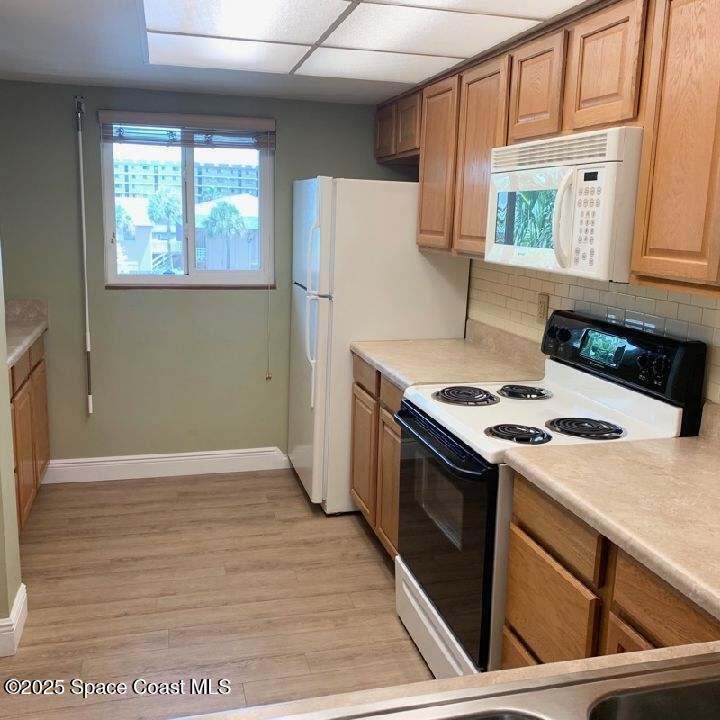 3060 North Atlantic Avenue, Unit 308 Cocoa Beach, FL 32931 - Photo 9 of 20 a kitchen with a stove and a refrigerator