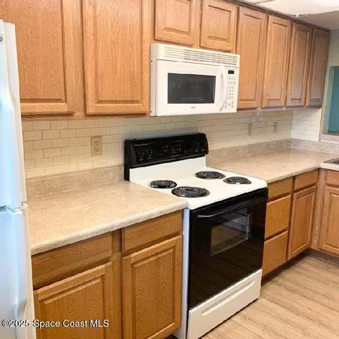 a kitchen with granite countertop cabinets stainless steel appliances and wooden floor