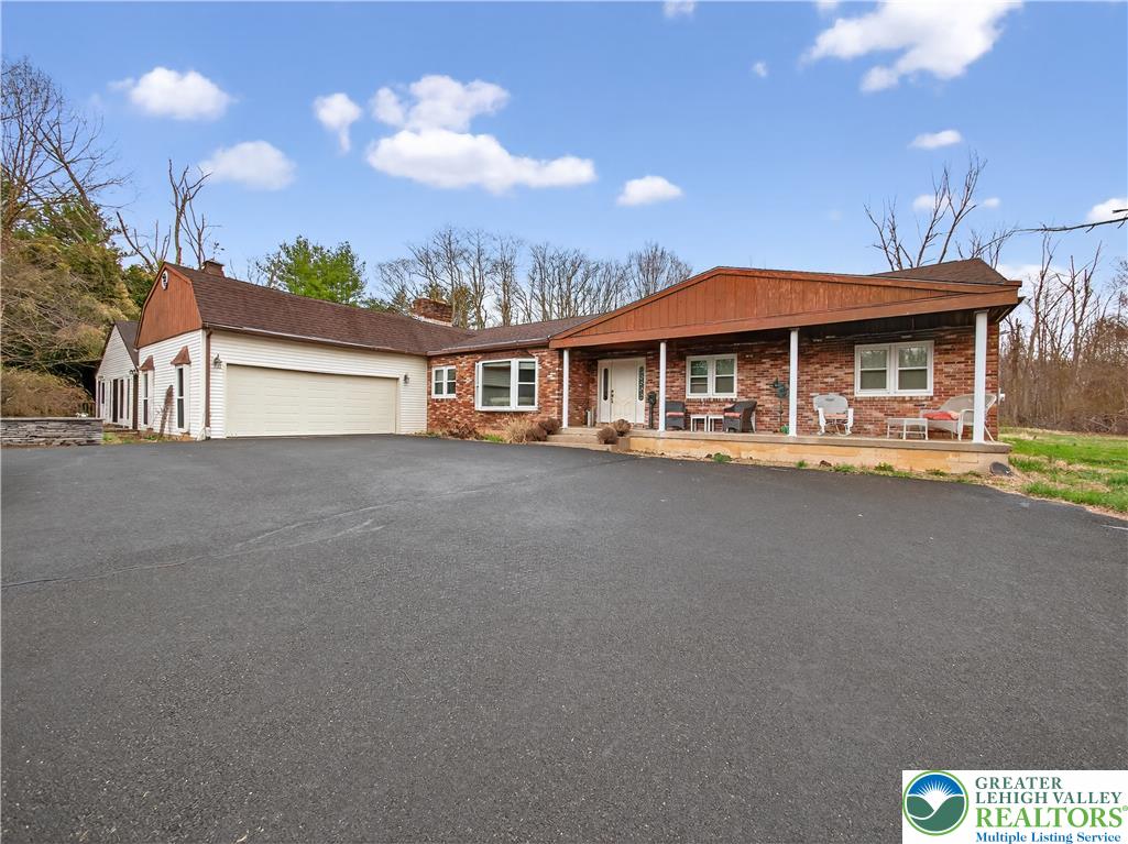2197 Buck Run Road Quakertown, PA 18951 - Photo 41 of 45 A long, paved driveway leads to a brick residence with a covered front porch.