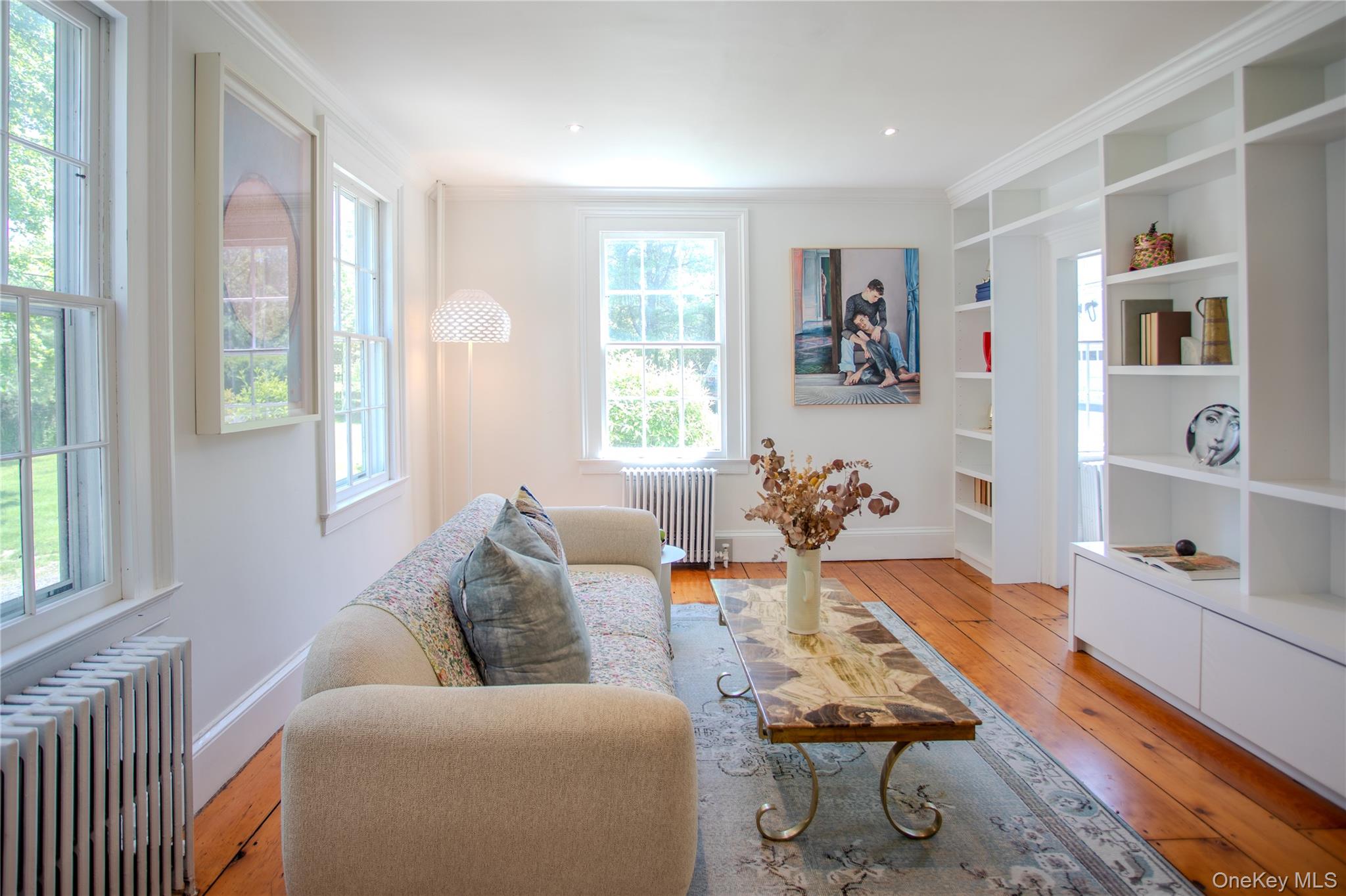 210 Middle Road Hudson, NY 12534 - Photo 14 of 42 Light-filled living space featuring multiple large windows, wide plank wood flooring, extensive built-in shelving
