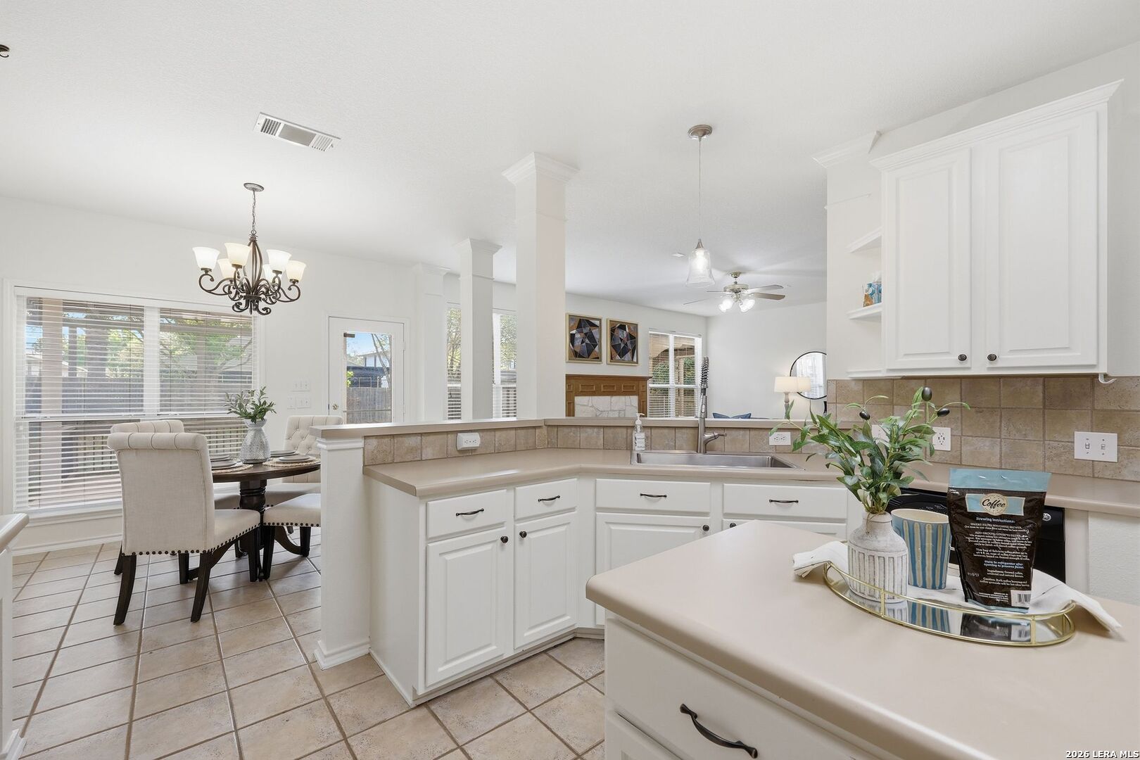 12910 Green Cedar Helotes, TX 78023 - Photo 13 of 65 a kitchen with a white table chairs and white cabinets