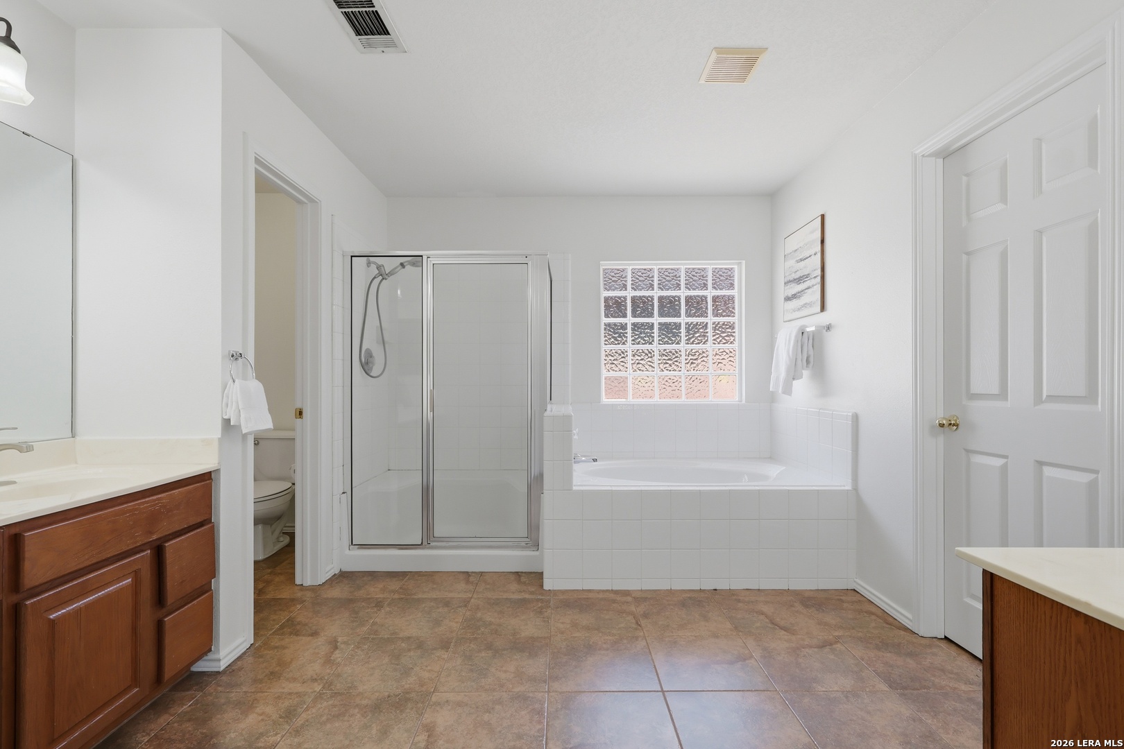 12910 Green Cedar Helotes, TX 78023 - Photo 29 of 65 a spacious bathroom with a granite countertop sink a mirror and a bathtub