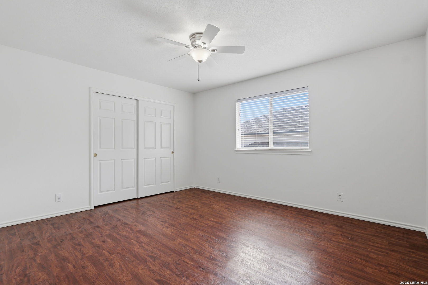 12910 Green Cedar Helotes, TX 78023 - Photo 48 of 65 an empty room with wooden floor chandelier fan and windows