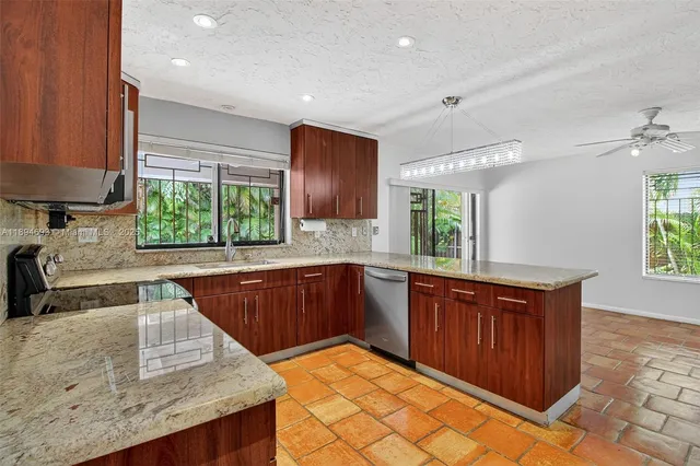 a kitchen with stainless steel appliances granite countertop a stove a sink dishwasher and a microwave oven with cabinets