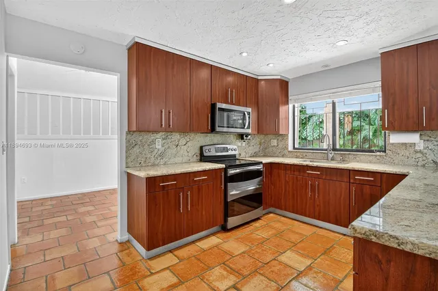 a kitchen with a stove a sink and a cabinets