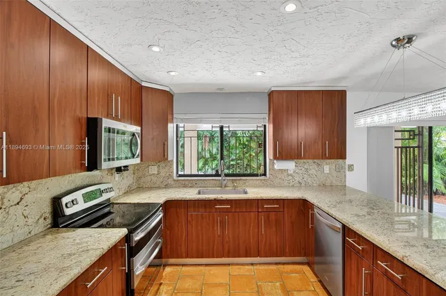 a kitchen with stainless steel appliances a refrigerator and a stove top oven