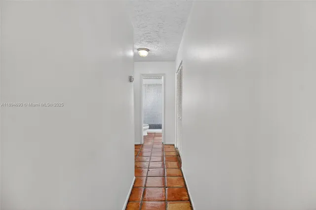 a view of a hallway with wooden cabinets and staircase