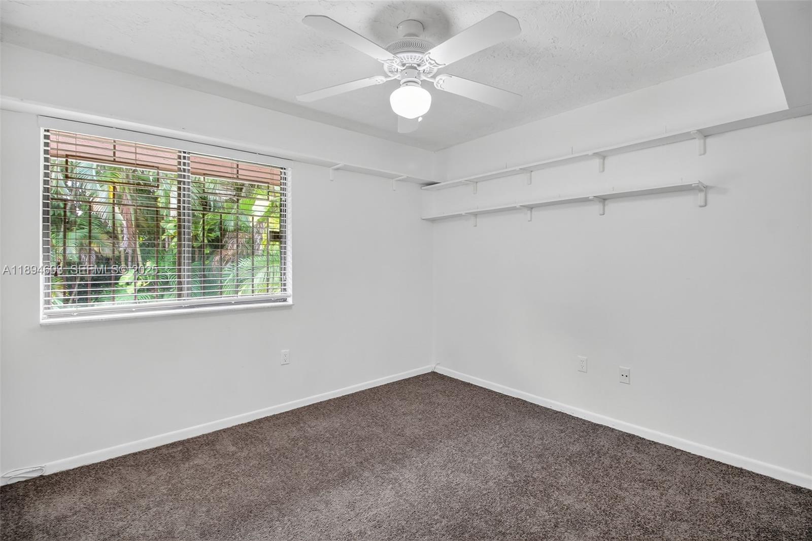 13830 Southwest 108th Street Miami, FL 33186 - Photo 29 of 40 an empty room with a window and a fan