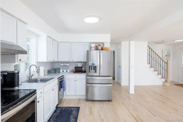 a kitchen with a refrigerator a sink and wooden cabinets
