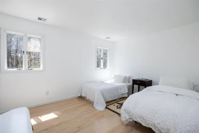 a spacious bedroom with two beds and a chair