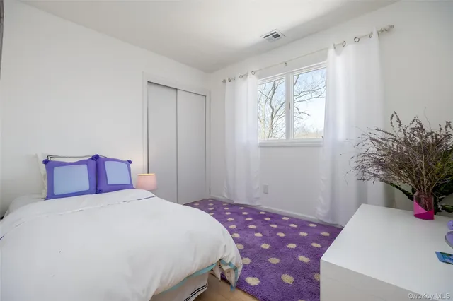 a bedroom with a bed and a potted plant