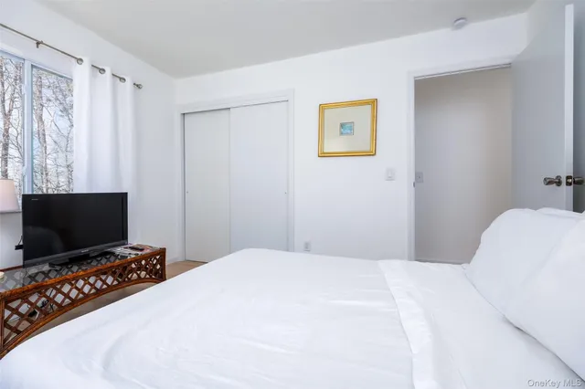 a bedroom with a bed and a flat screen tv