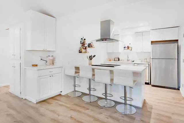 a kitchen with appliances cabinets and wooden floor